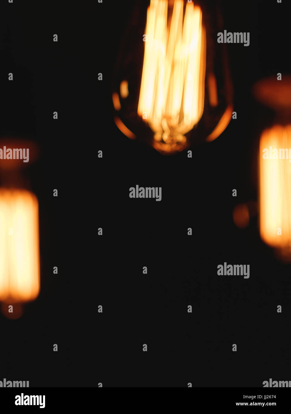 Image floue des ampoules rétro rougeoyant dans la nuit. Banque D'Images