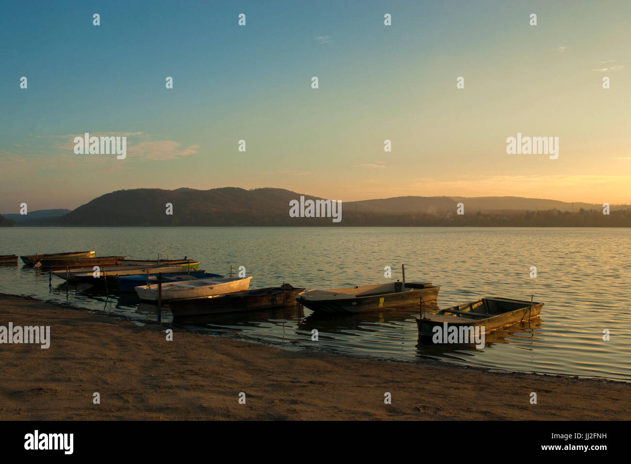 Bateau de pêche sur le lac en automne coucher du soleil Banque D'Images