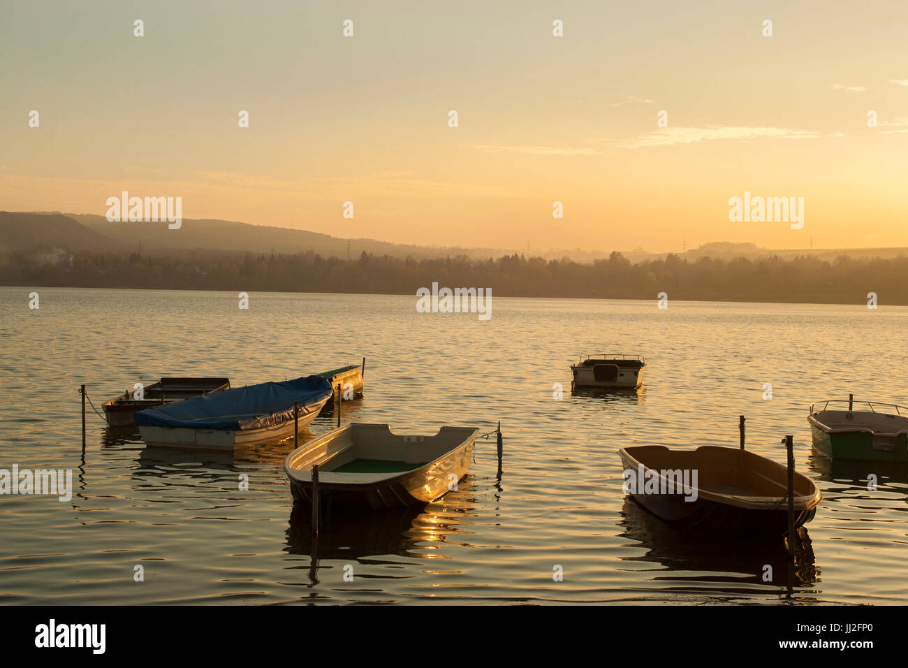 Bateau de pêche sur le lac en automne coucher du soleil Banque D'Images