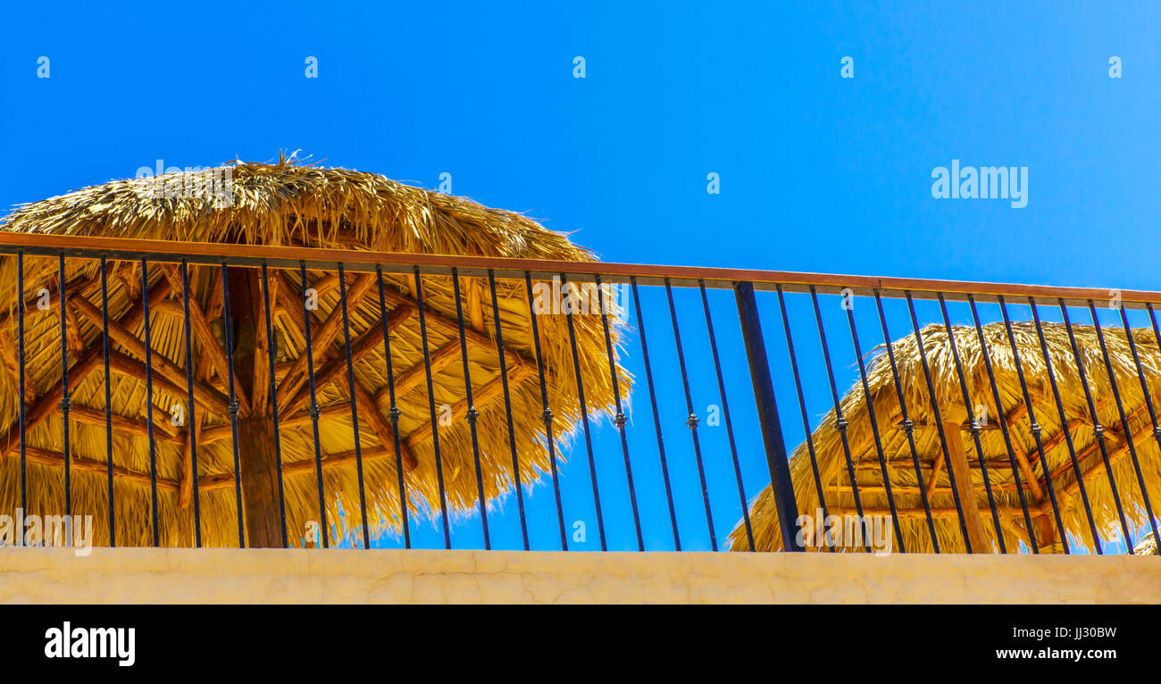 Tiki de paille des parasols sur un restaurant sur le toit Banque D'Images