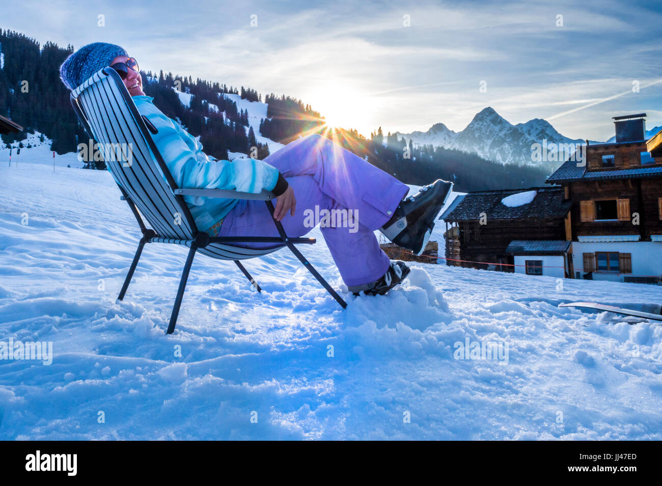 Woman relaxing in deck chair après le ski Banque D'Images