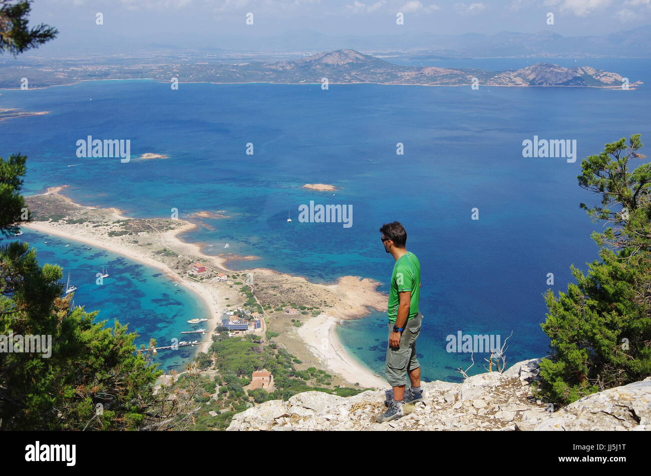 Male hiker (jeune adulte) sur la piste vers le sommet de Tavolara, lookng vers la mer ci-dessous. Banque D'Images