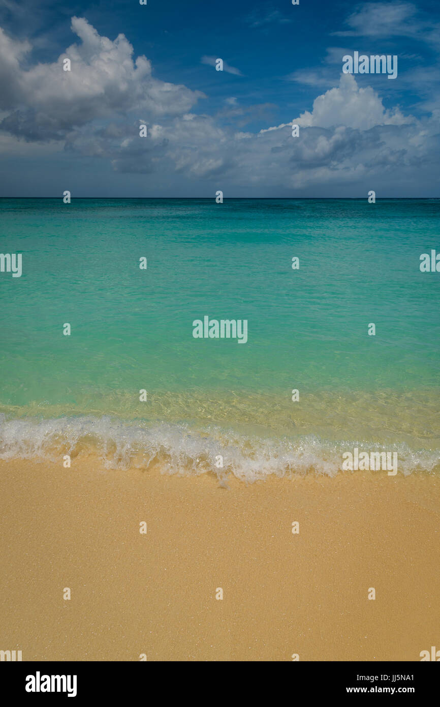 Une petite vague s'écrase sur Seven Mile Beach Grand Cayman. Banque D'Images