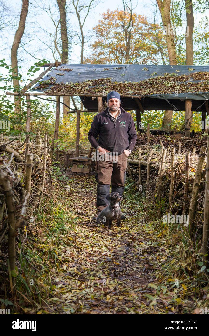 Mark Eccleston et son chien Bertie. Il est un ancien signaleur ferroviaire, qui loue sept acres de forêts régénérées à Telford, Shropshire. United Kingdom Banque D'Images