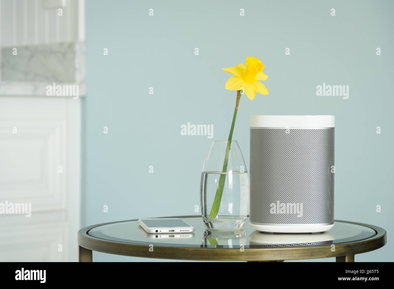 Le président sans fil et téléphone mobile sur une table avec un miroir jaune jonquille. Banque D'Images