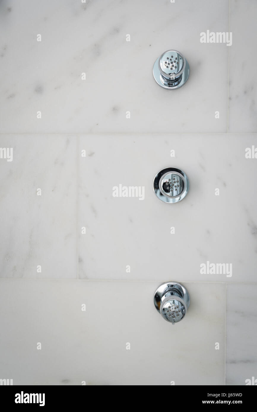 Trois jets de douche chrome monté sur le marbre blanc de Carrare. Banque D'Images
