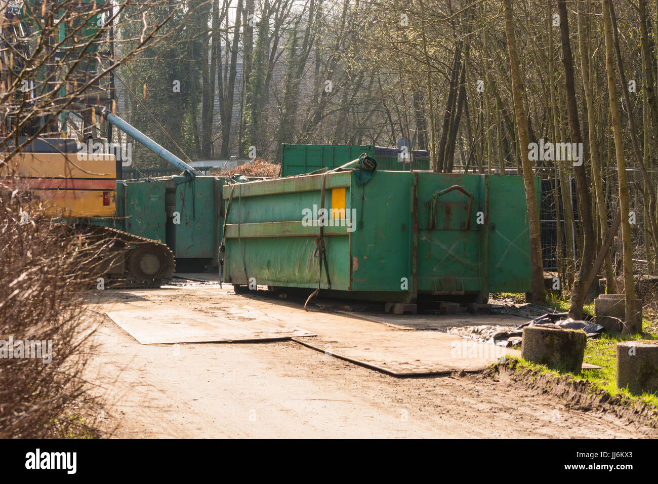 Conteneur vert et de l'excavateur sur un chantier de construction dans la forêt. Banque D'Images