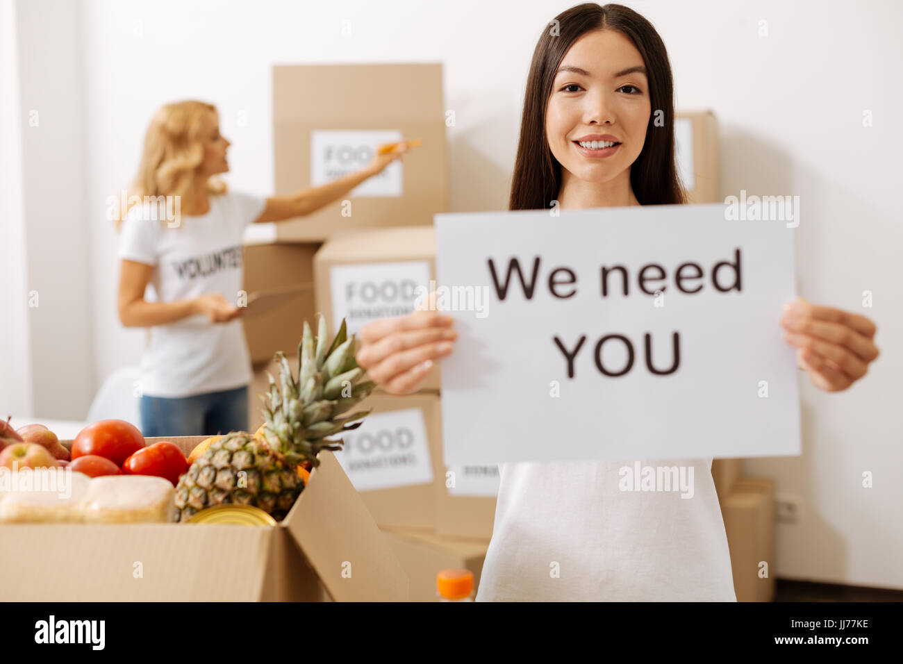 Ouvert d'esprit cheerful woman holding une affiche annonçant la charité Banque D'Images