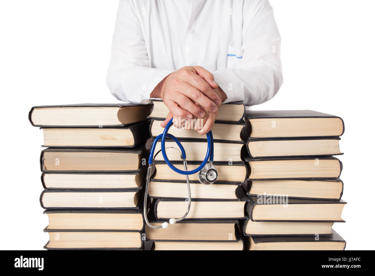 Médecin Senior en tunique blanche et stéthoscope leaning sur de nombreux livres et manuels empilés. Banque D'Images