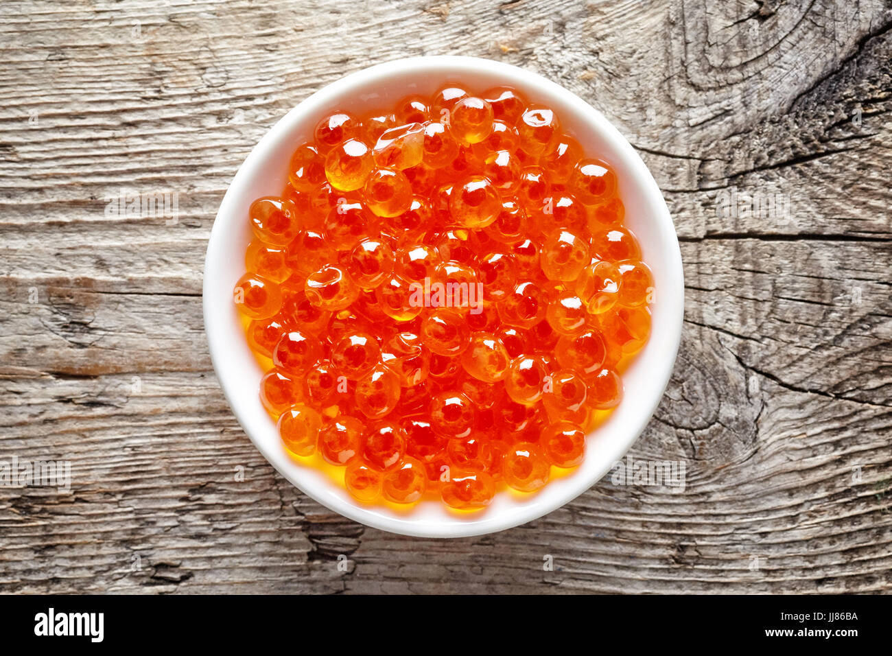 Bol de caviar rouge sur fond de bois, vue du dessus Banque D'Images