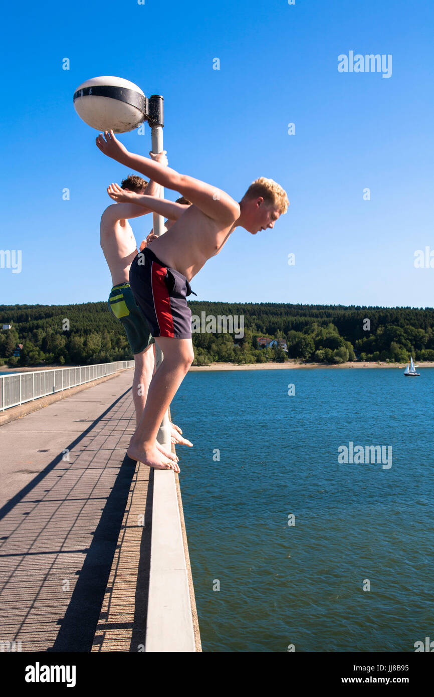 DEU, l'Allemagne, région du Sauerland, Moehnesee, les garçons en sautant d'un pont dans le lac Moehne. DEU, Deutschland, Sauerland, Moehnesee, Jungens springen von Banque D'Images