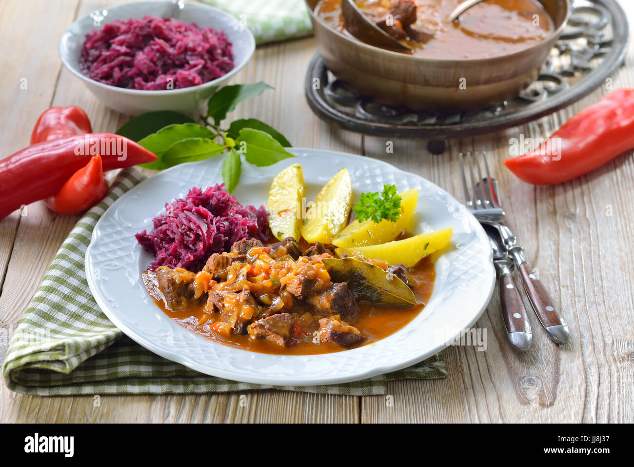 Goulash hongrois chaud servi avec pommes persillées au beurre et de chou rouge Banque D'Images