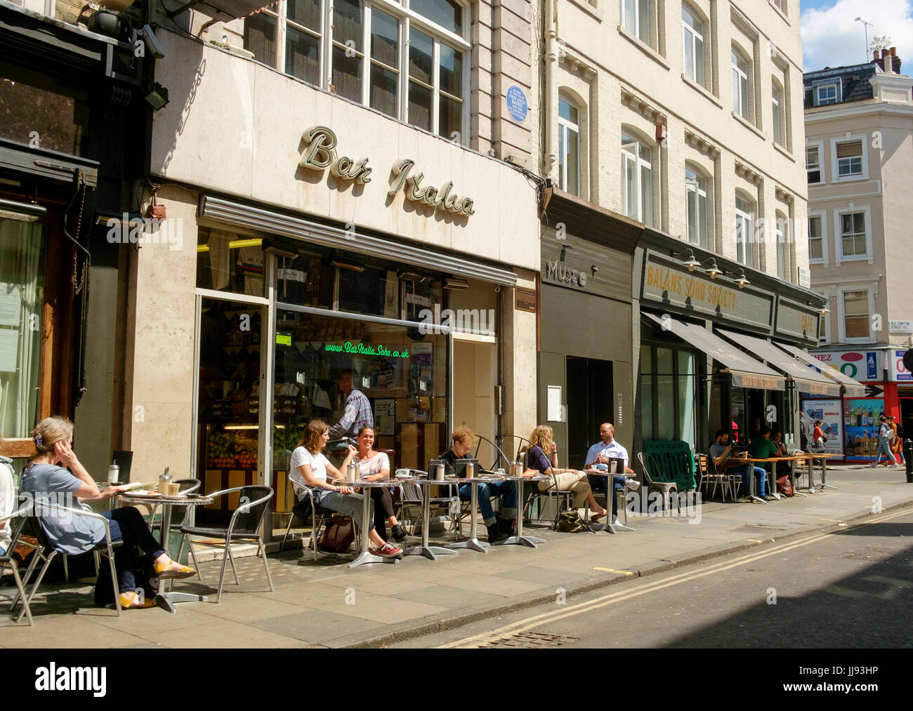 Des gens assis sur le trottoir à l'extérieur Bar Italia, Frith Street, Soho, Londres Banque D'Images