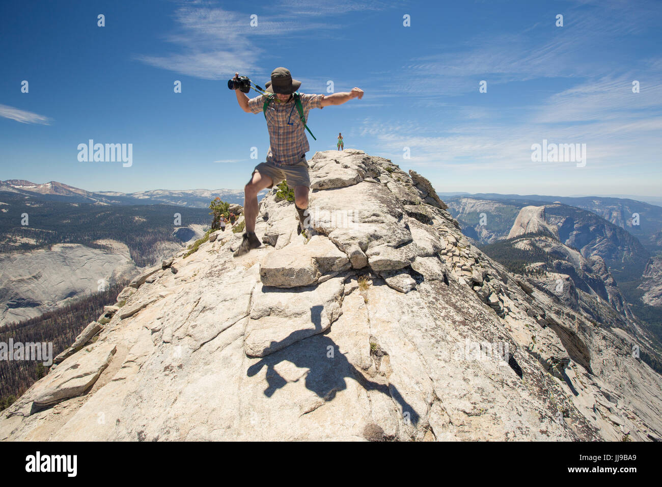 Un homme bondit en l'air après une randonnée Les nuages reste dans le Parc National Yosemite. Banque D'Images