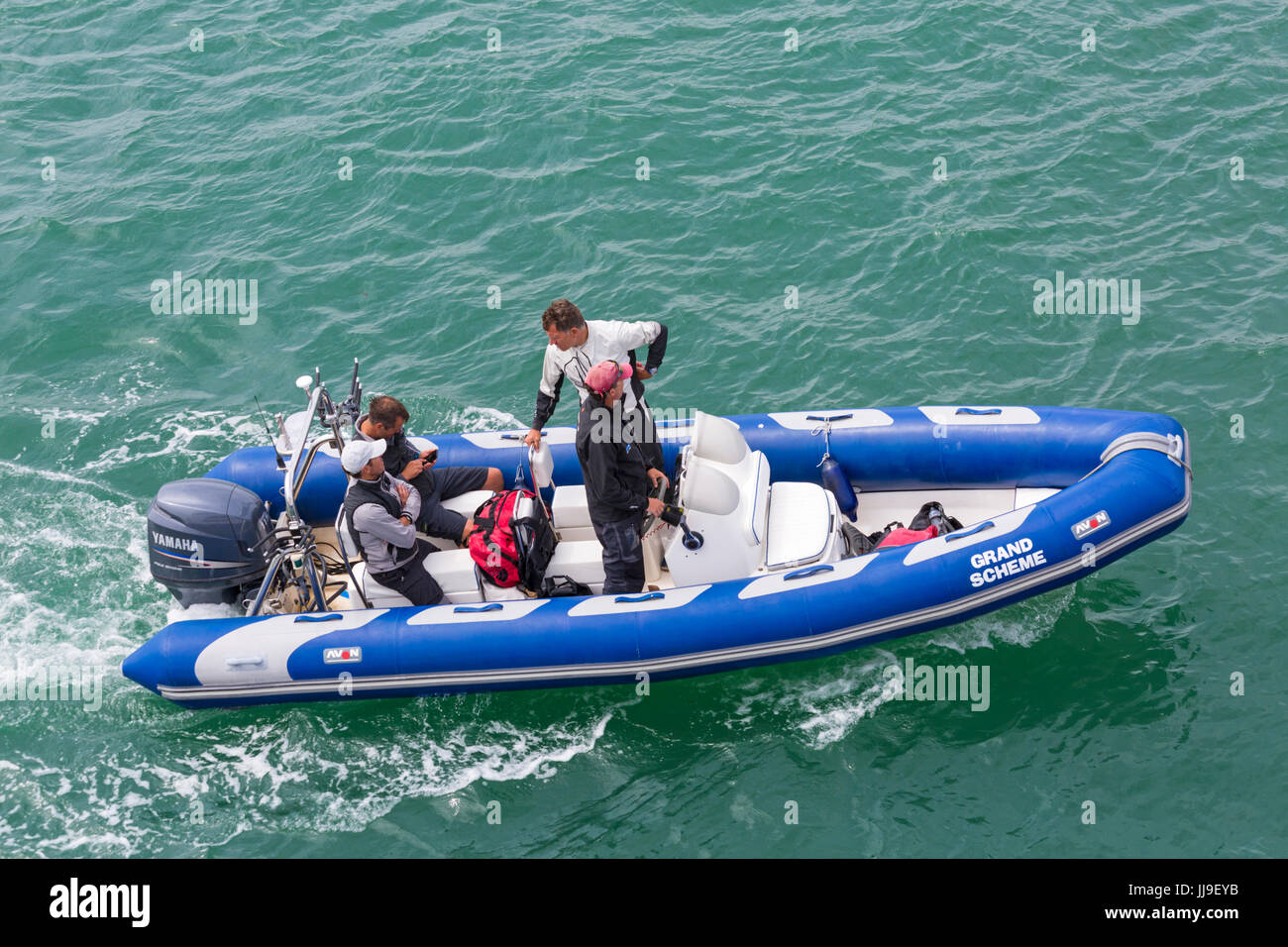 Quatre hommes dans la région de Avon Inflatable Boat boating dans le Solent entre Lymington et Yarmouth, Isle of Wight, Hampshire, Royaume-Uni en juillet Banque D'Images