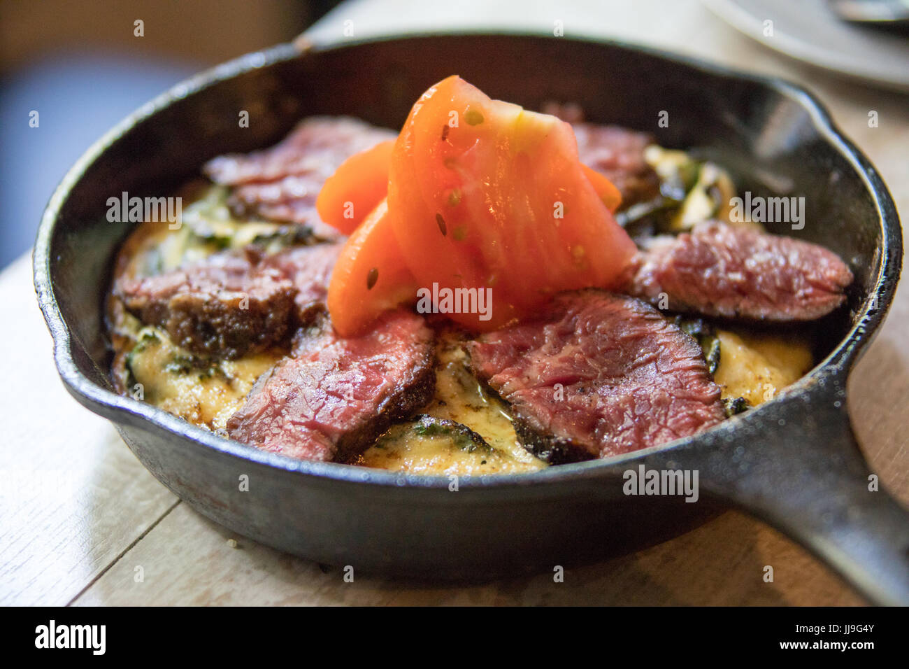 Frittata au steak à l'ail, tomates marinées à l'aïoli Cuisine Jeudi, East Village, New York City Banque D'Images