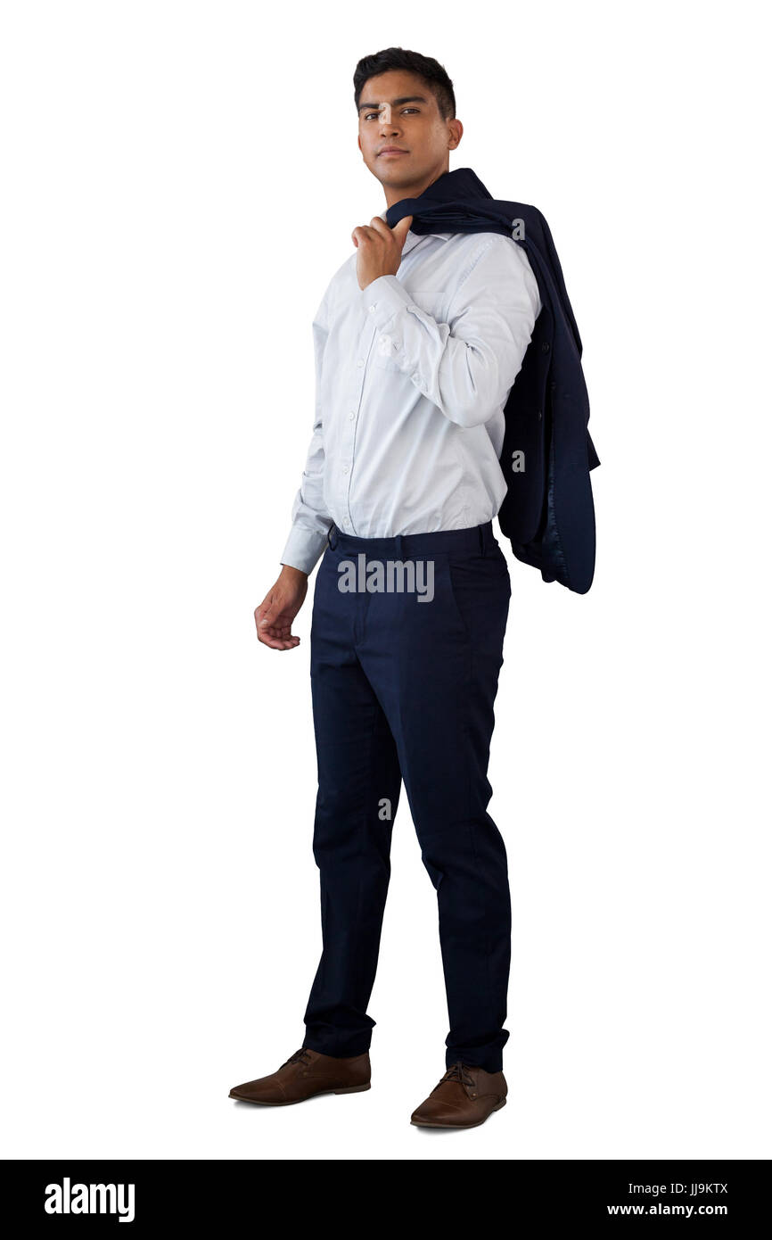 Portrait of young businessman holding suit sur l'épaule tandis que standing against white background Banque D'Images