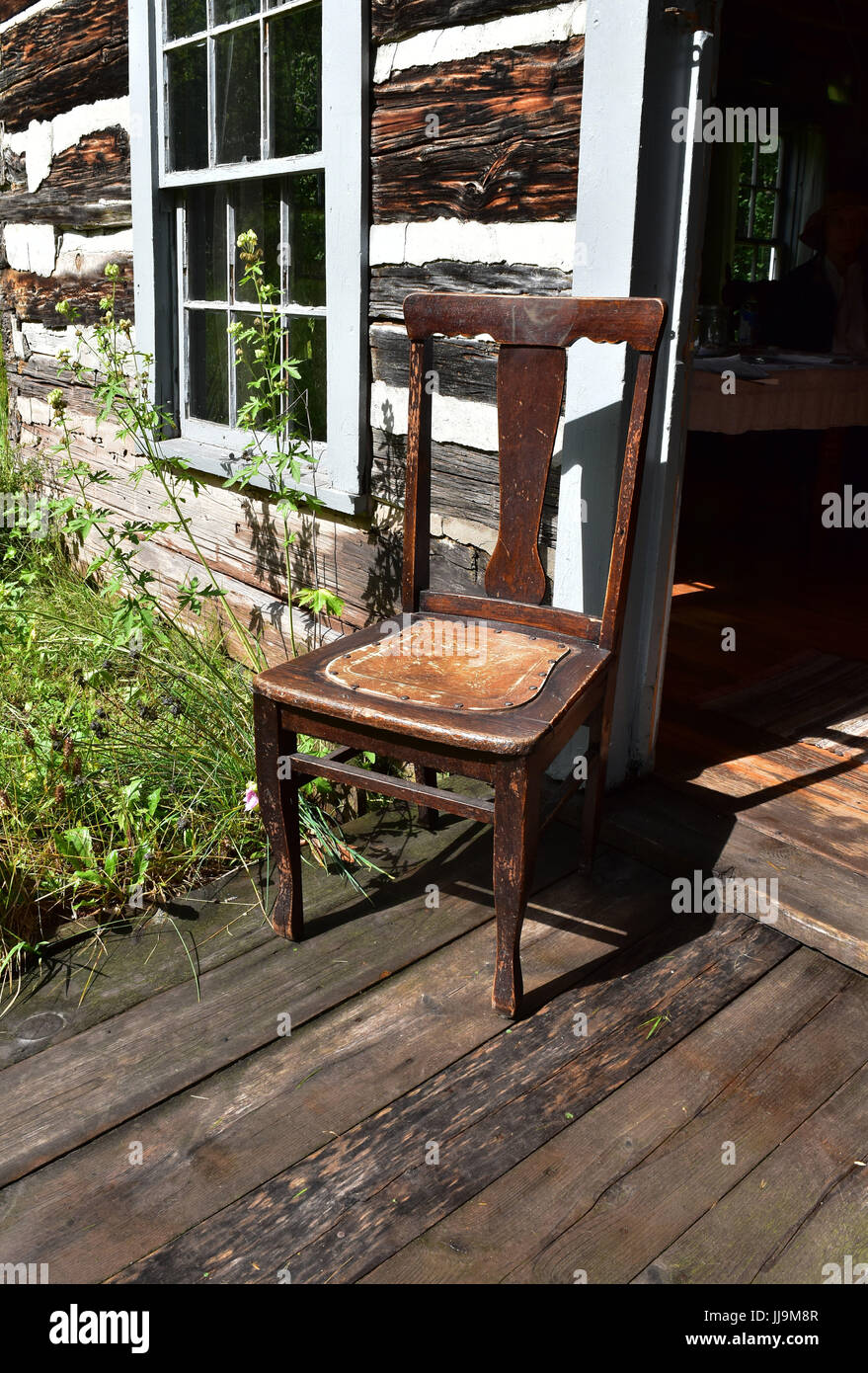 Vieille chaise dans la porte d'une cabane rustique Banque D'Images