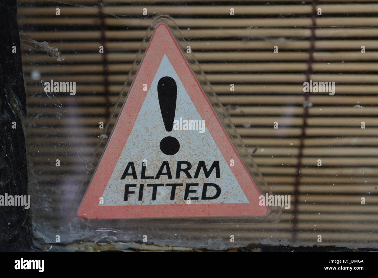 Équipé d'alarme signe triangulaire sticker sur vitre close up re panneau d'avertissement de sécurité accueil maison cambriolage Vol d'arrêt Banque D'Images