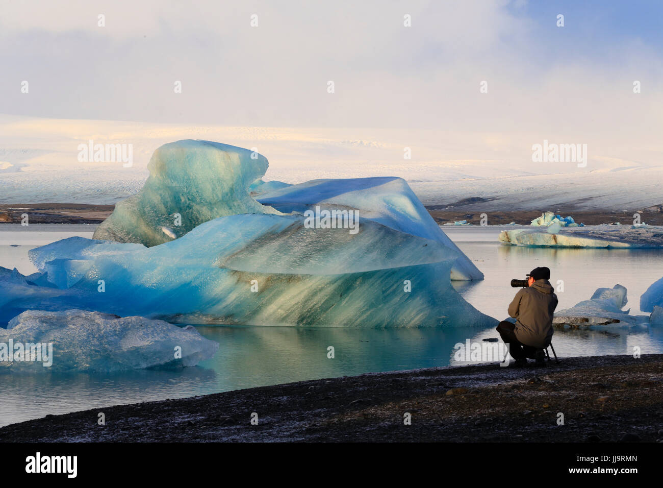 Photographe au glacier Jökulsárlón lagoon, Iceland, photographiant des icebergs qui viennent de la glacier Breiðamerkurjökull qui alimente dans la lagune. Banque D'Images