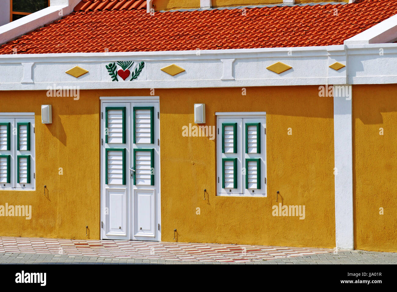 Dutch artchitecture distinctes sur l'île d'Aruba est mis en évidence dans ce bâtiment en ciment avec le toit en pente et les volets de la porte et windows Banque D'Images