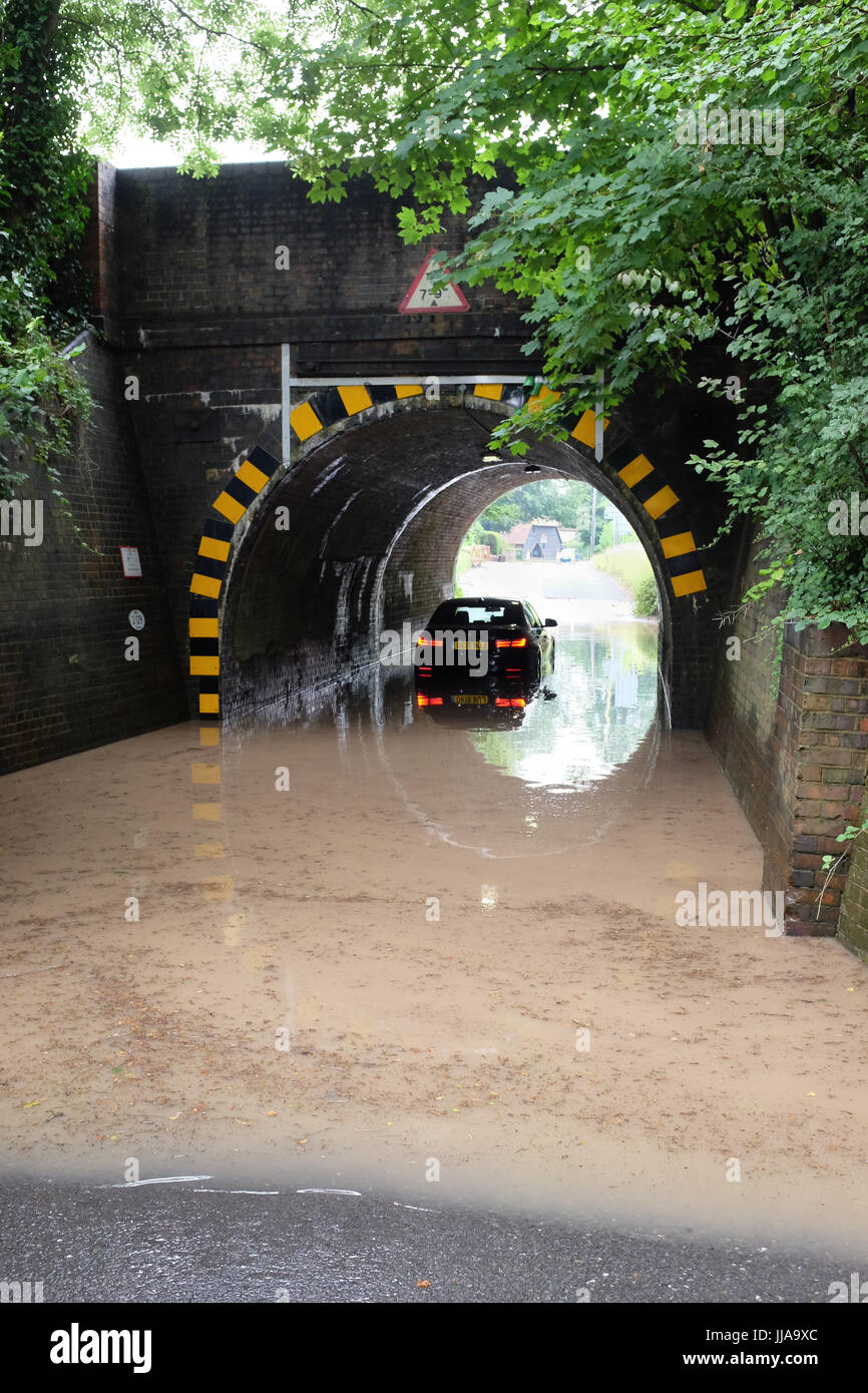 En fondant, Hampshire. 19 juillet, 2017. Un pilote doit attendre pour obtenir de l'aide le mercredi matin après que leur voiture est coincée dans une inondation sous un pont de chemin de fer dans le village de fonder, près de Basingstoke, Hampshire. Du jour au lendemain tempêtes ont causé de lourds dommages à travers le sud du pays. Crédit : Trevor Mogg / Alamy Live News Banque D'Images