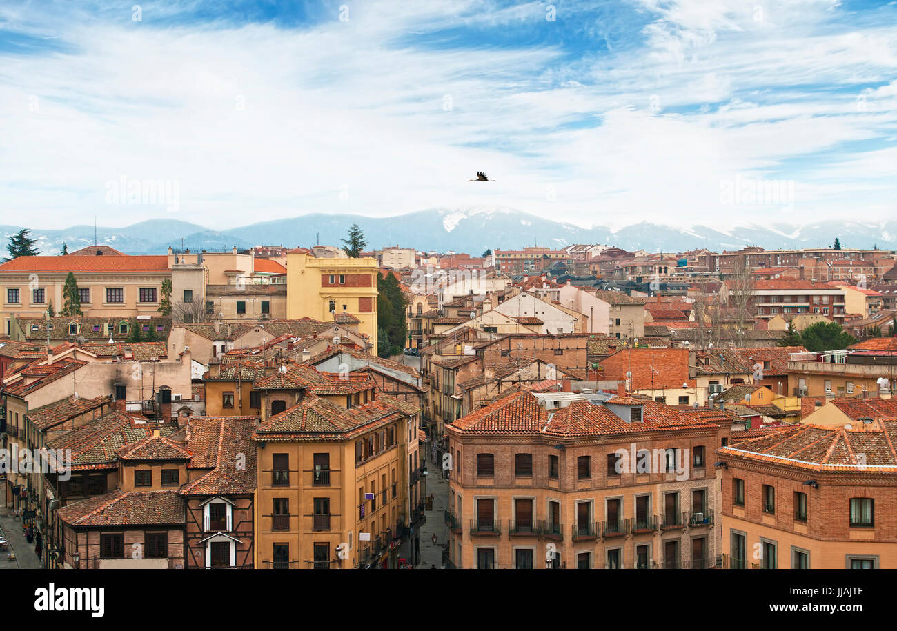 Vue aérienne de la vieille ville espagnole de Barcelone au début du printemps avec des montagnes aux sommets enneigés en arrière-plan et d'une cigogne survolant la ville, Barcelone, Espagne Banque D'Images