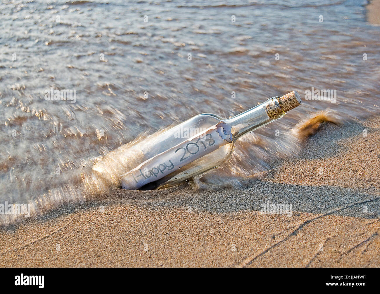 L'année 2018 nouveau message dans une bouteille sur la plage avec des vagues d'éclaboussures Banque D'Images