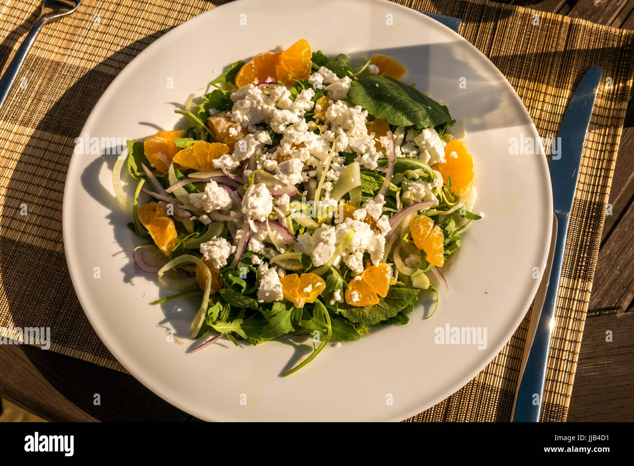 Close up de salade d'été servis à l'extérieur sur le pont dans le jardin table sun avec les clémentines, roquette, fenouil, endives, fromage feta, Ecosse, Royaume-Uni Banque D'Images