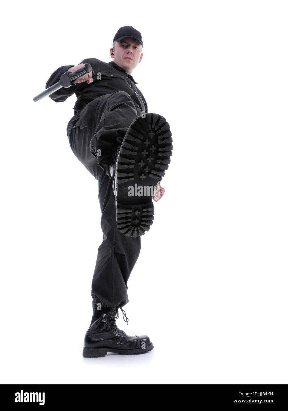 Policier portant uniforme noir faire un kick, shot on white Banque D'Images