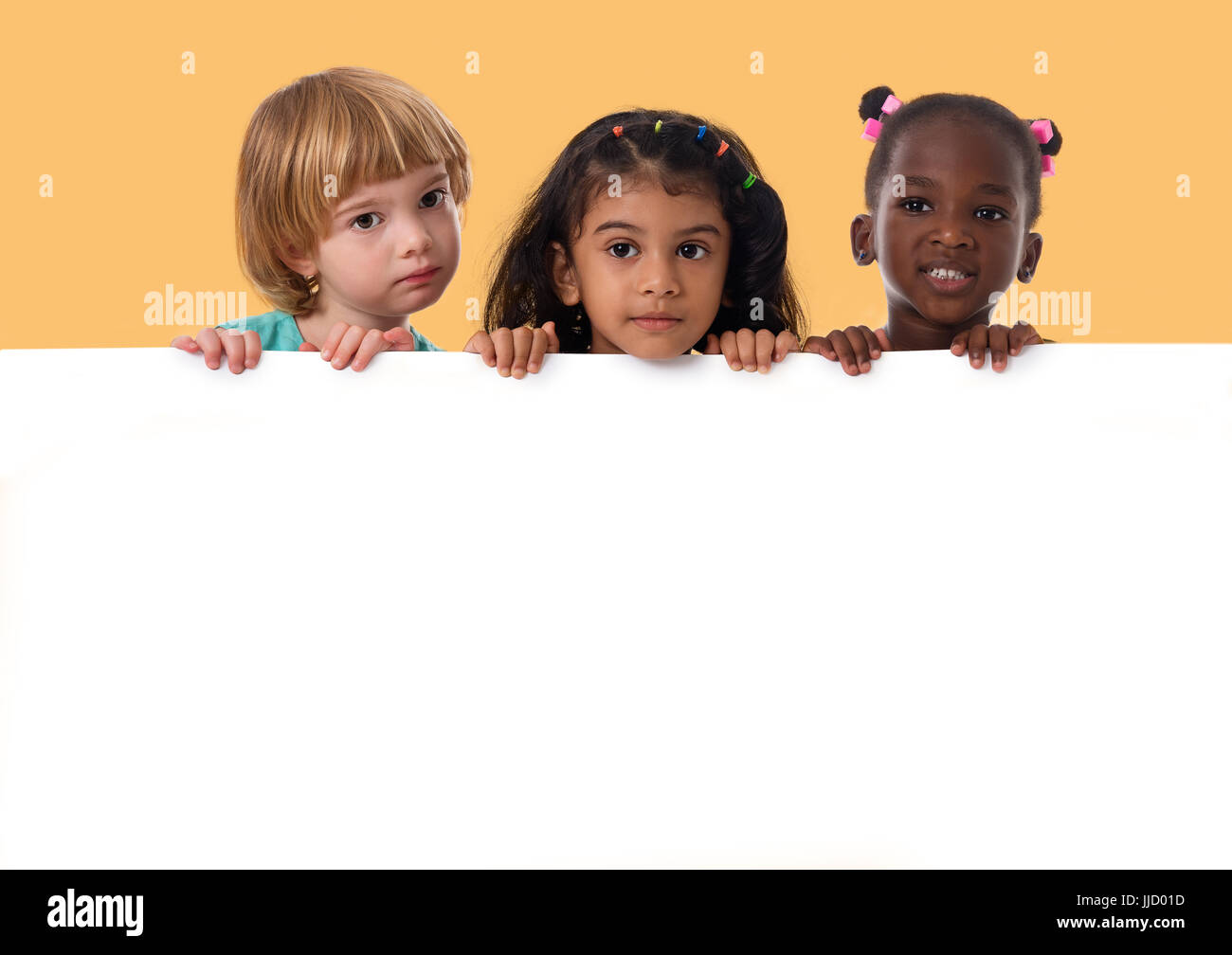 Groupe d'enfants multiraciale portrait en studio avec tableau blanc isolé. Banque D'Images