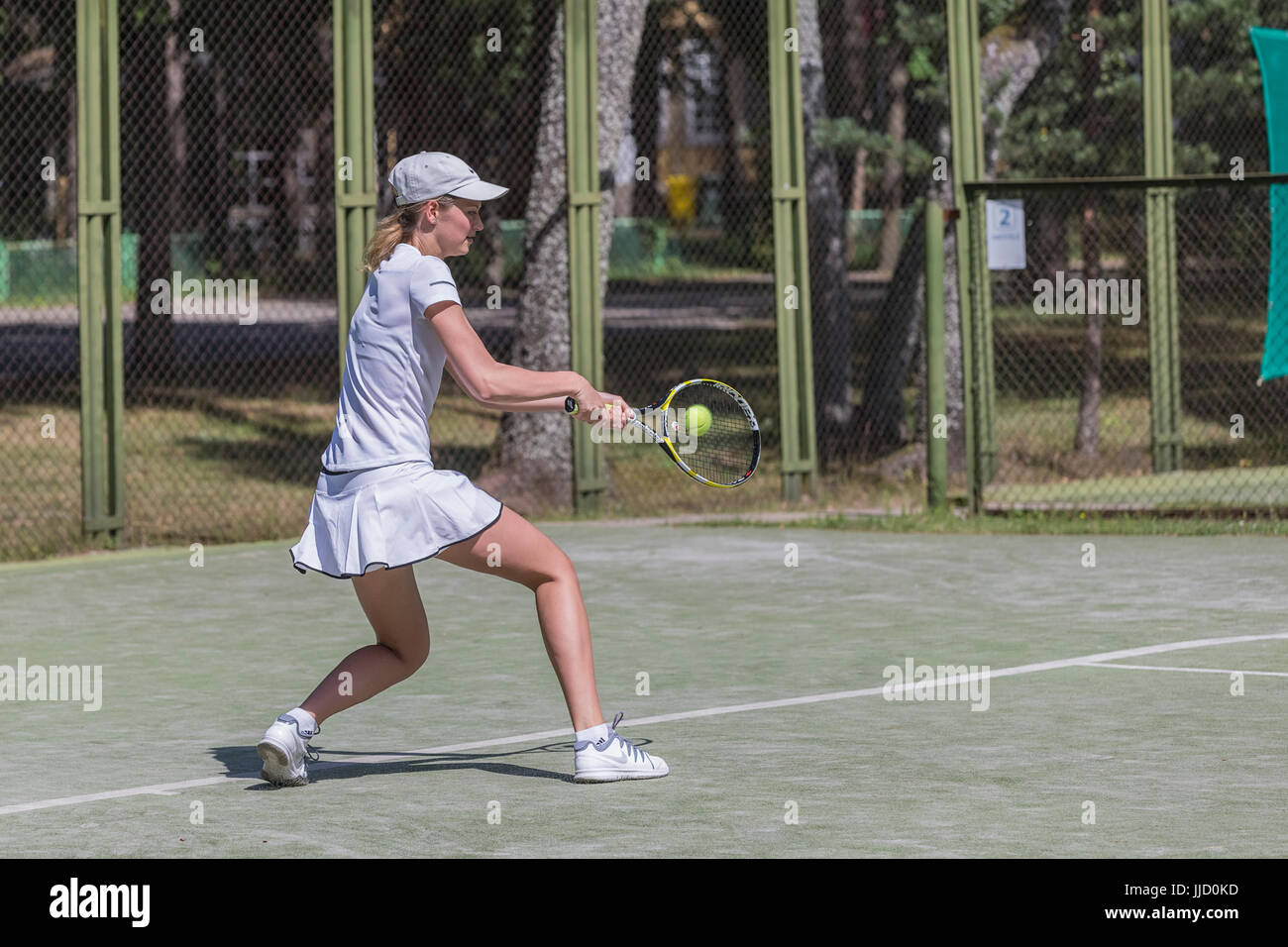 Tennis player hitting ball sur le terrain de tennis, Palanga, Lituanie. Banque D'Images