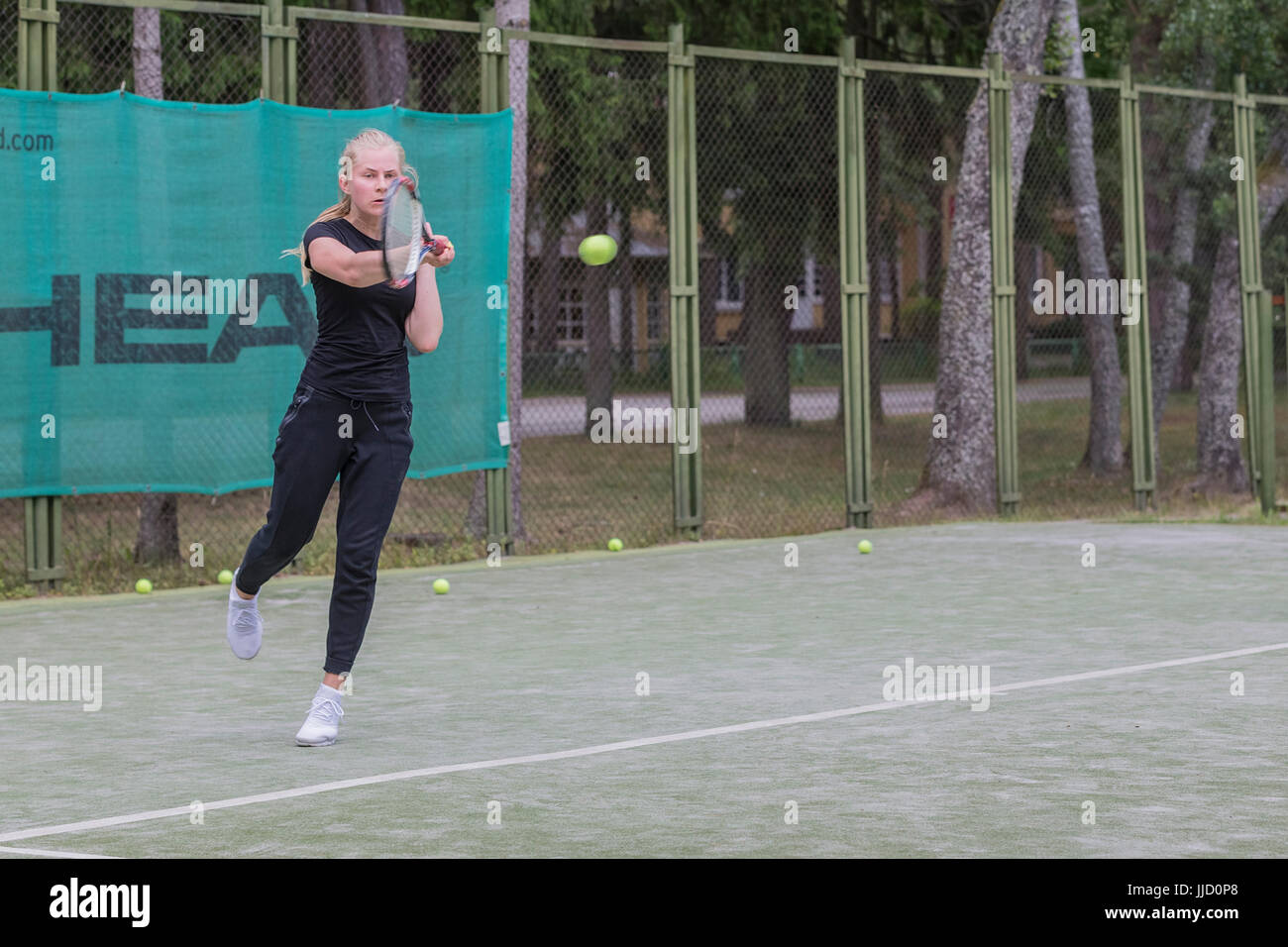 Tennis player hitting ball sur le terrain de tennis, Palanga, Lituanie. Banque D'Images