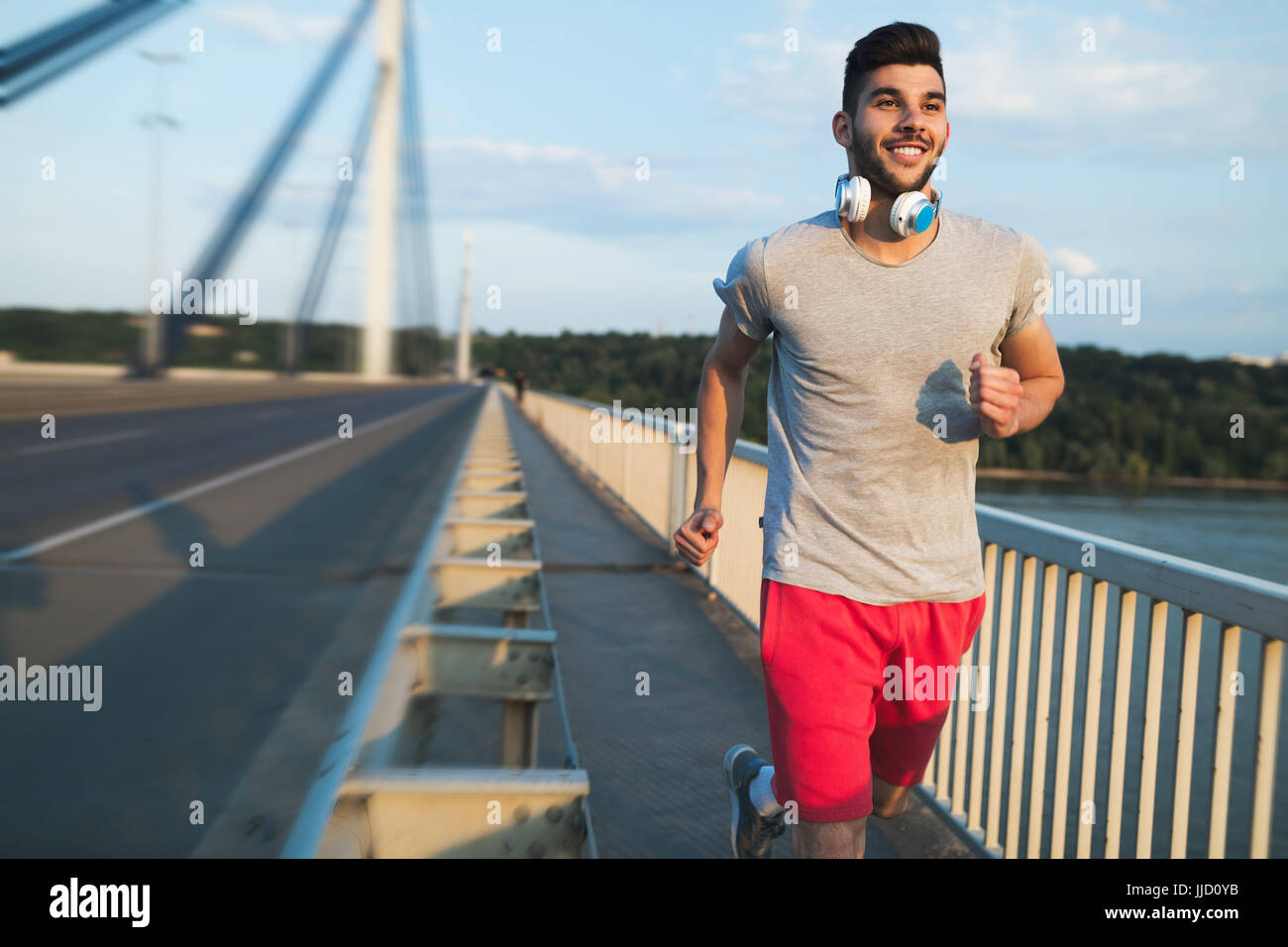 Portrait of handsome man running on bridge Banque D'Images