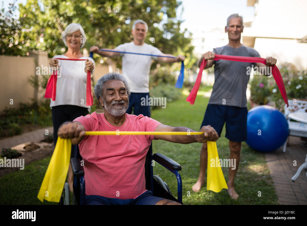 Handicap physique senior man holding ruban avec les amis tout en s'exerçant à park Banque D'Images