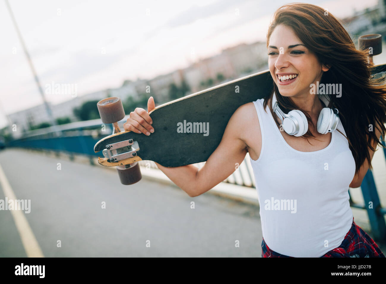 Portrait of beautiful smiling girl skateboard transport Banque D'Images