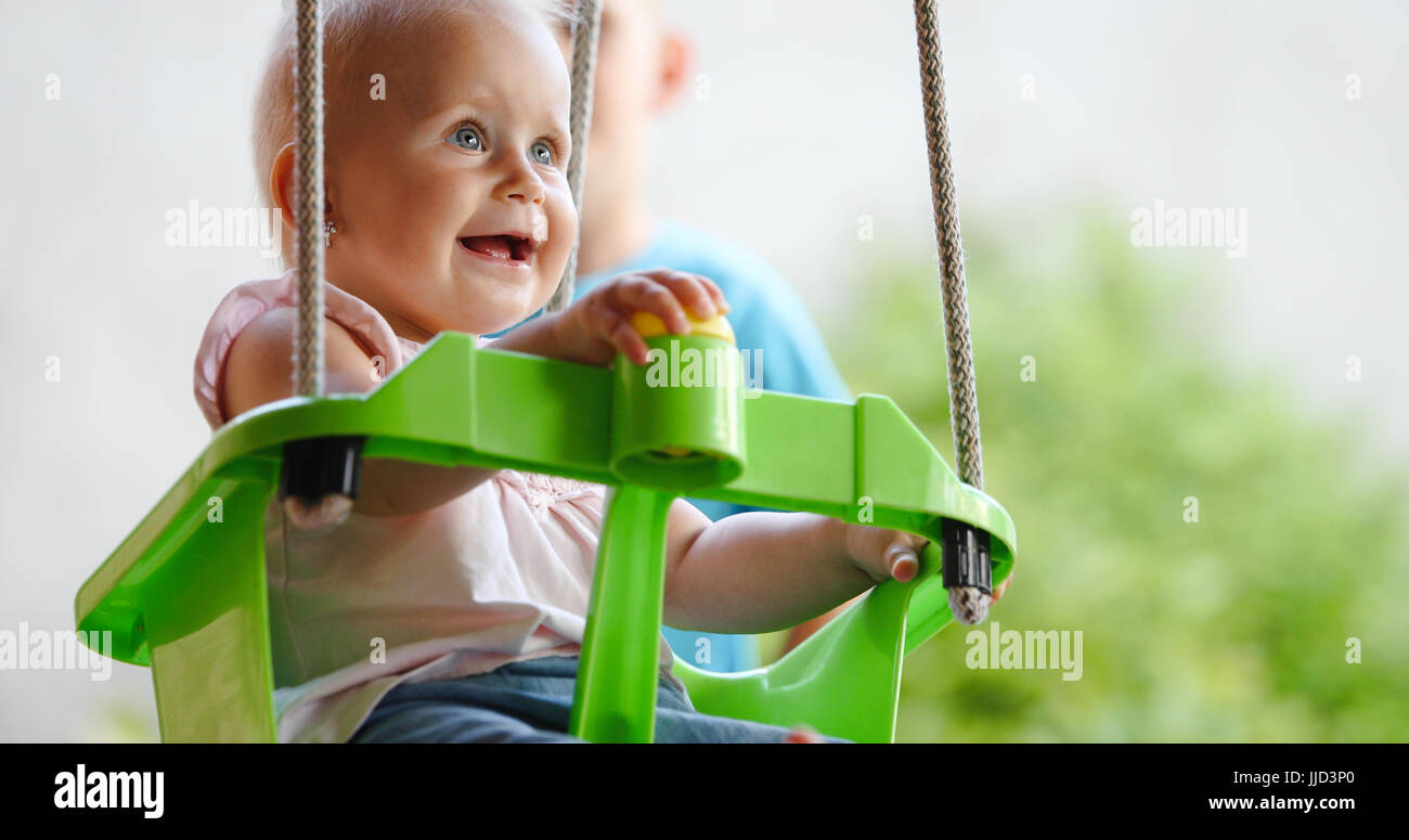 Happy cheerful baby smiling while on swing Banque D'Images