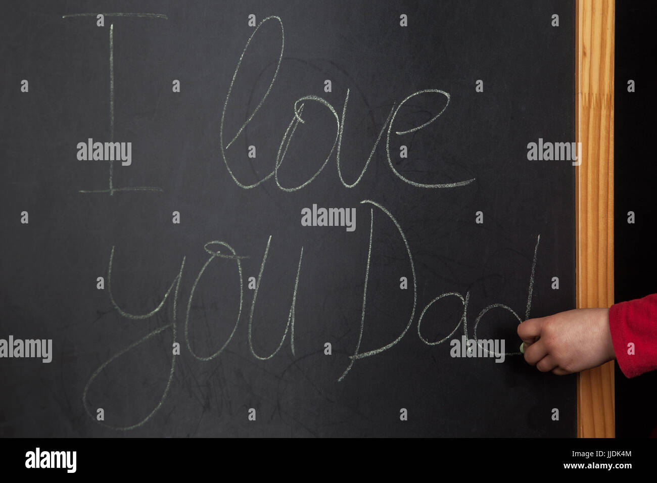 Mots QUE J'aime papa writeen sur tableau noir avec craie main tenant l'enfant Banque D'Images