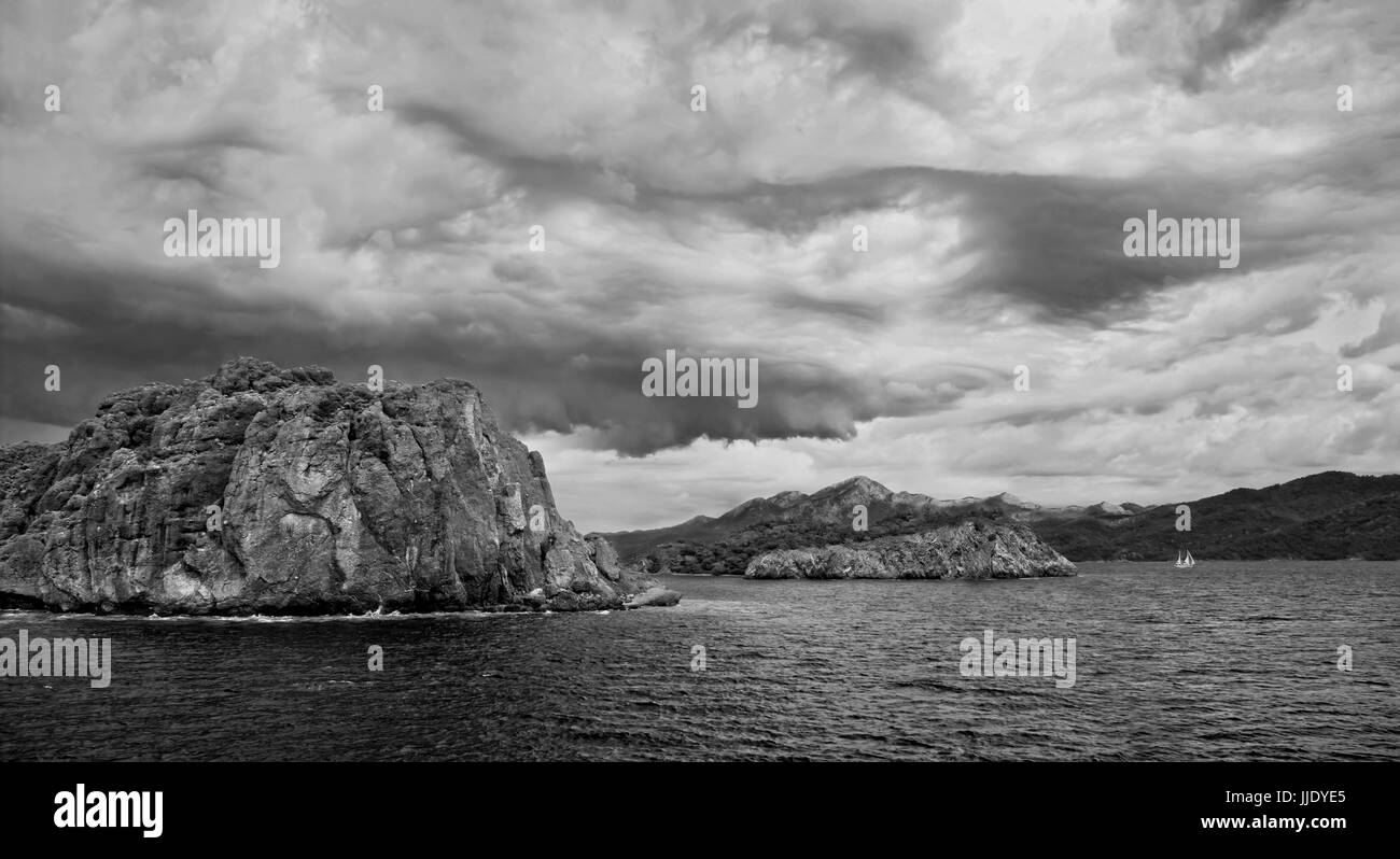 Vue panoramique en noir et blanc d'îles rocheuses dans la mer Égée sur jour de tempête, Turquie Banque D'Images