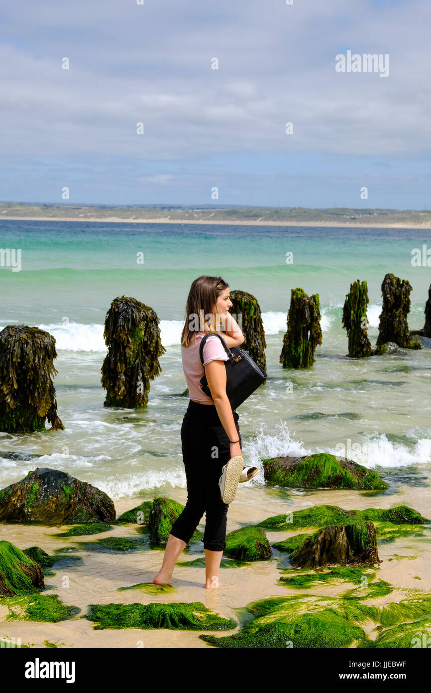 Jeune femme pagayer dans la mer à St Ives, Cornwall Banque D'Images