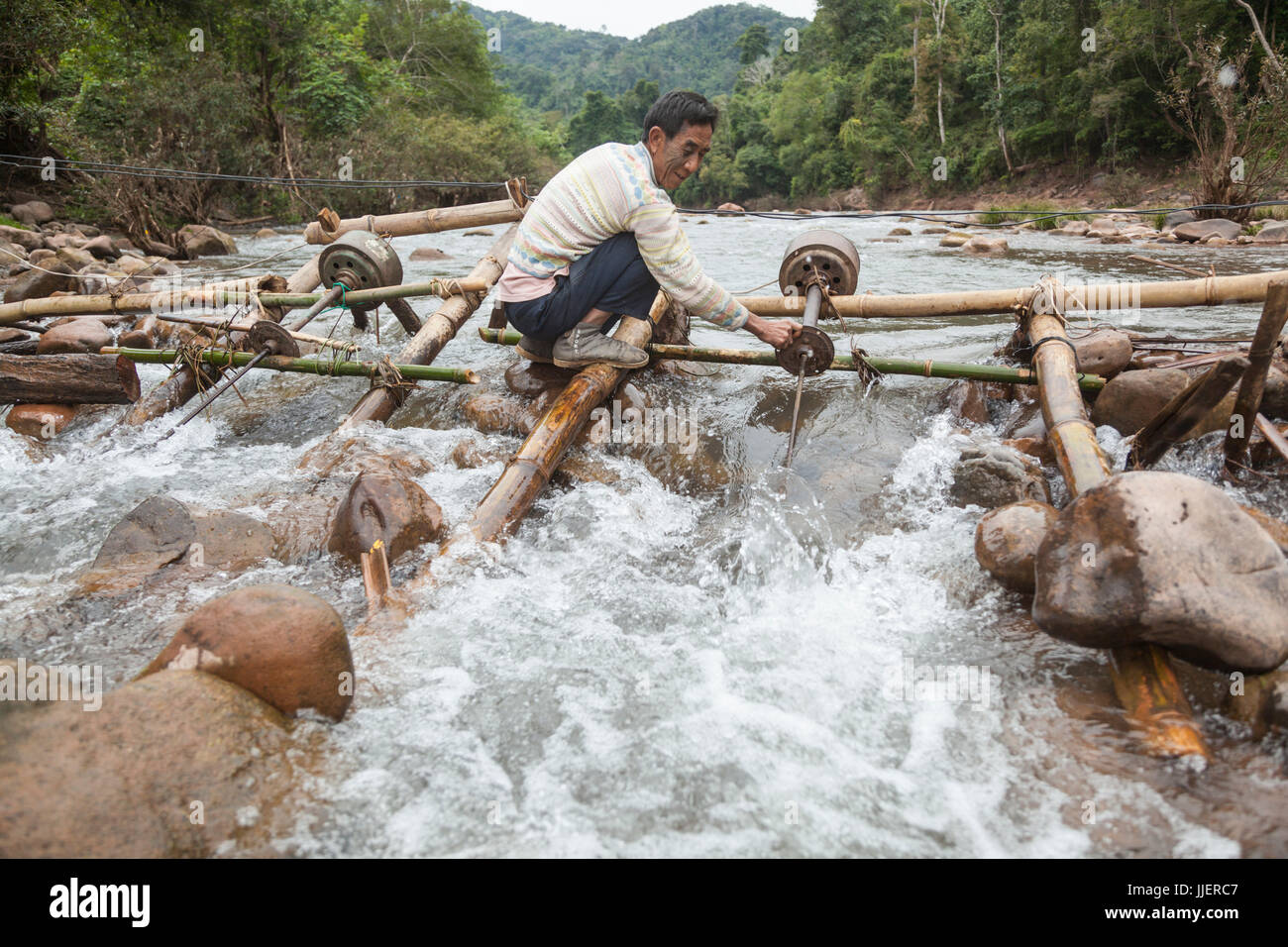 Un homme règle le bateau (hélice) sur une micro turbine hydro dans l'écoulement de la rivière Nam Ou à Ban Sop Kha, le Laos. Les turbines sont utilisées par tous les villages le long de la rivière pour produire de l'électricité, au moins pendant la saison sèche, quand le niveau d'eau est suffisamment bas pour les monter au lit de la rivière. Banque D'Images