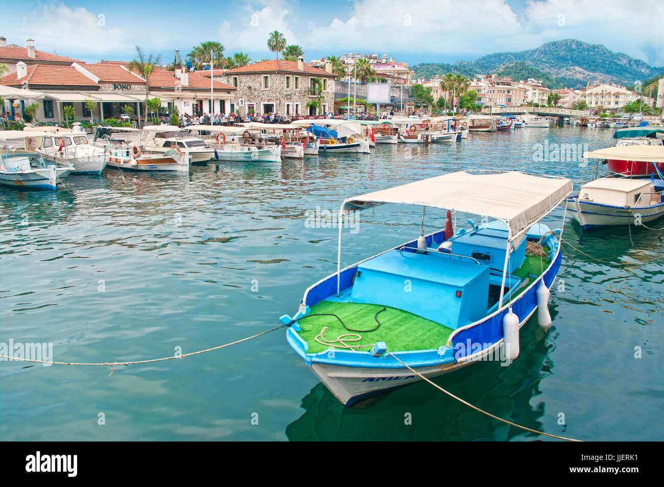 MARMARIS, TURQUIE - 10 MAI 2015 : les petits bateaux amarrés le long de canal dans le centre-ville de Marmaris avec les gens assis dans les restaurants autour et montagnes à zone Banque D'Images