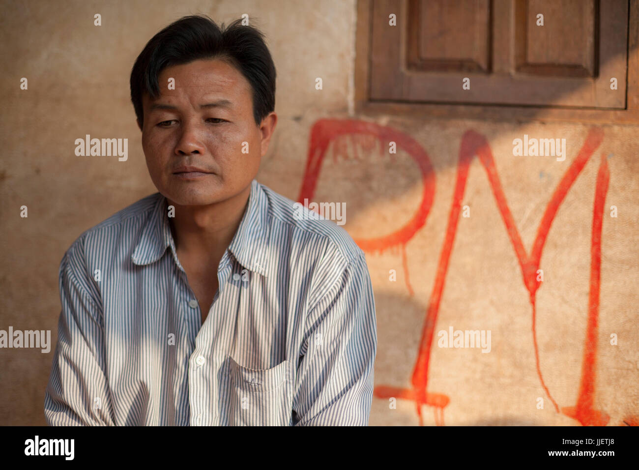Un chef de village est situé en face de l'accueil à Ban Phu Muang, au Laos. Les marquages rouges ont été faites par les représentants du gouvernement Lao, marquage chaque maison d'une valeur de remplacement pour l'indemnisation après l'inondation du village par le barrage de la rivière Nam Ou # 6. Banque D'Images