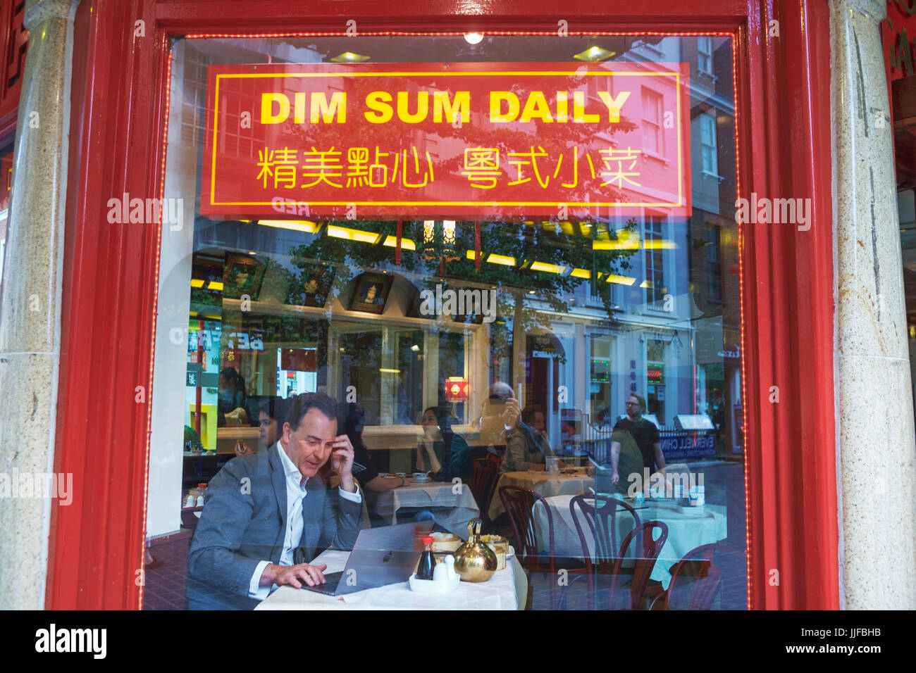 Restaurant chinois Soho Londres Royaume-Uni. Businessman en utilisant l'ordinateur. Dim Sum quotidiennement. Banque D'Images