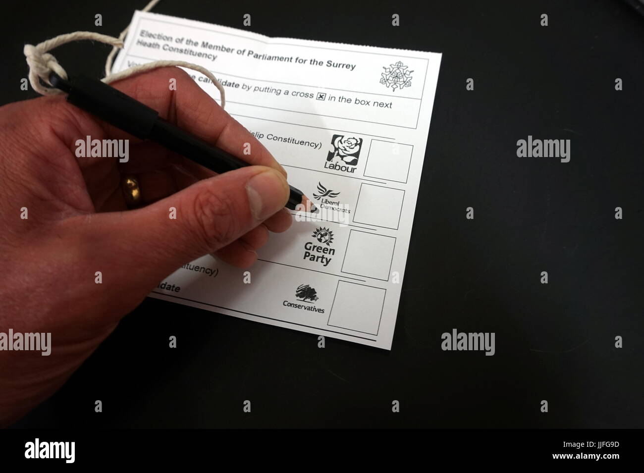 Camberley, UK - 8 juin 2017 : Main de l'homme de décider de la façon de voter à l'élection générale BRITANNIQUE Banque D'Images