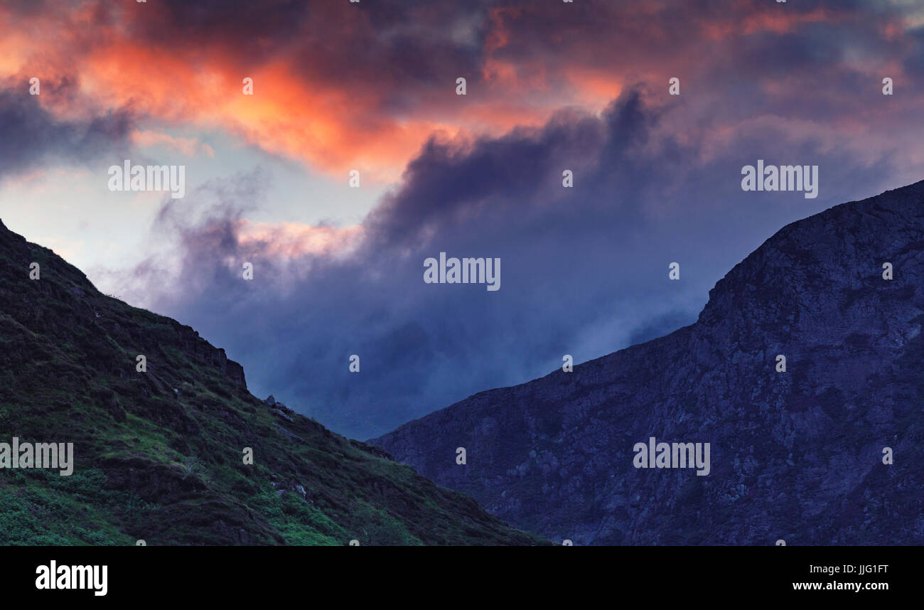 Spectaculaire coucher de soleil nuages colorés sur nant Gwynant Valley Hills dans la région de Snowdonia, UK Banque D'Images