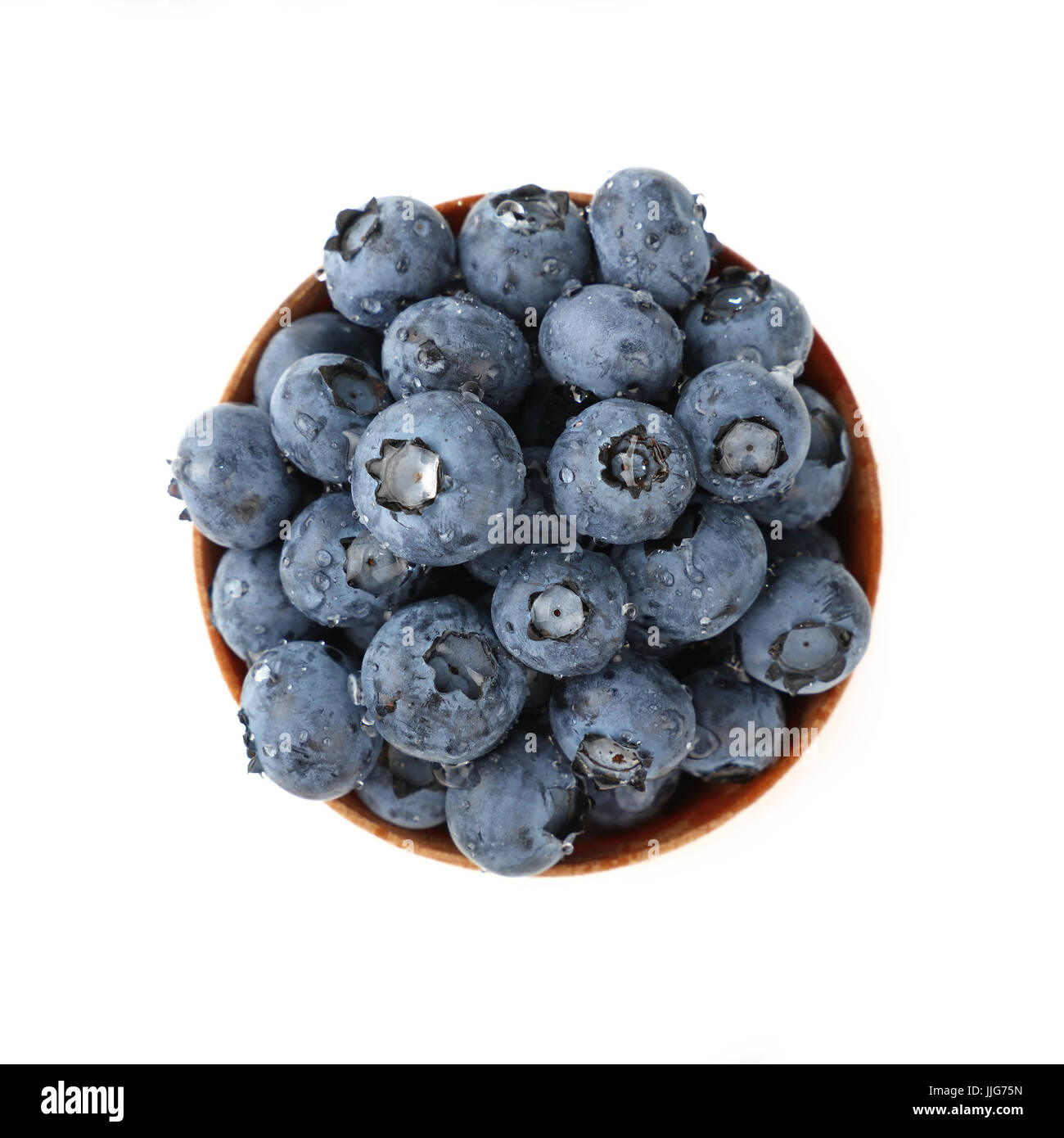 Partie de petits fruits bleuets frais lavés dans un bol en bois rustique, humide avec de l'eau baisse, isolé sur fond blanc, Close up, augmentation de la vue de dessus, dire Banque D'Images