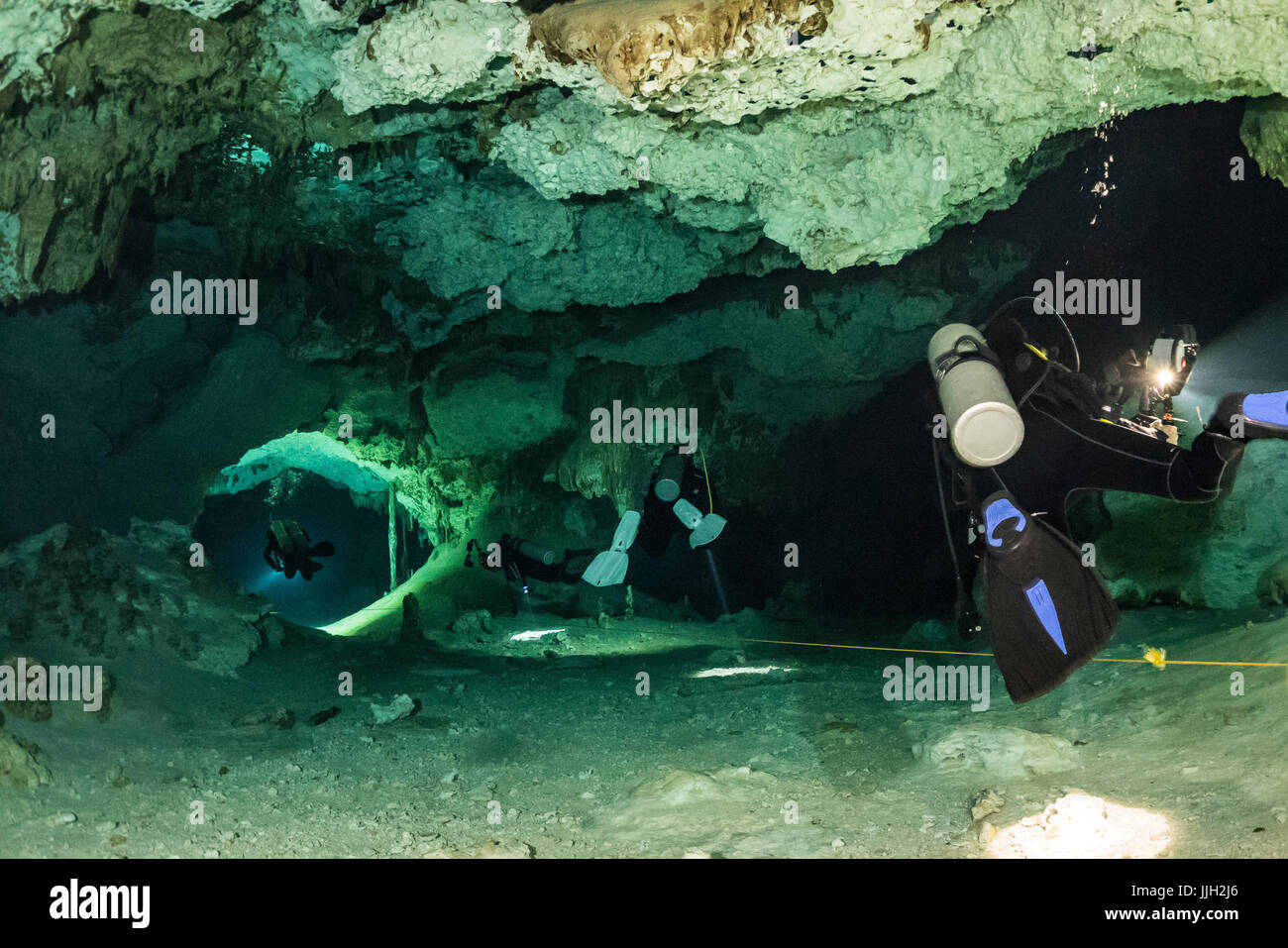 Les plongeurs d'explorer les passages de la célèbre Mexique Dos Ojos Cenote. Banque D'Images