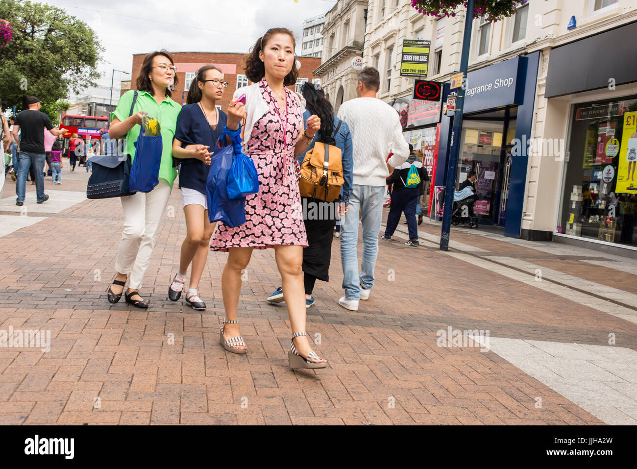 Femmes chinoises la marche et shopping dans la rue Clarence , la principale rue commerçante piétonne en Kingston Upon Thames, Londres , Royaume-Uni Banque D'Images