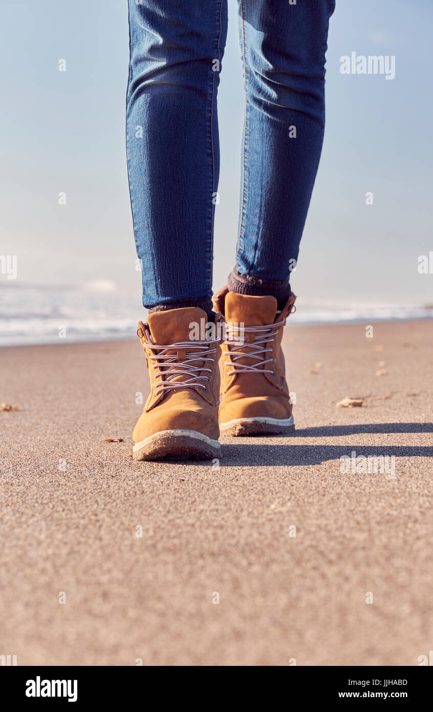 Une jeune femme marche sur la plage. Banque D'Images